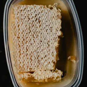Top view of a fresh honeycomb in a plastic container, sweet and nutritious.